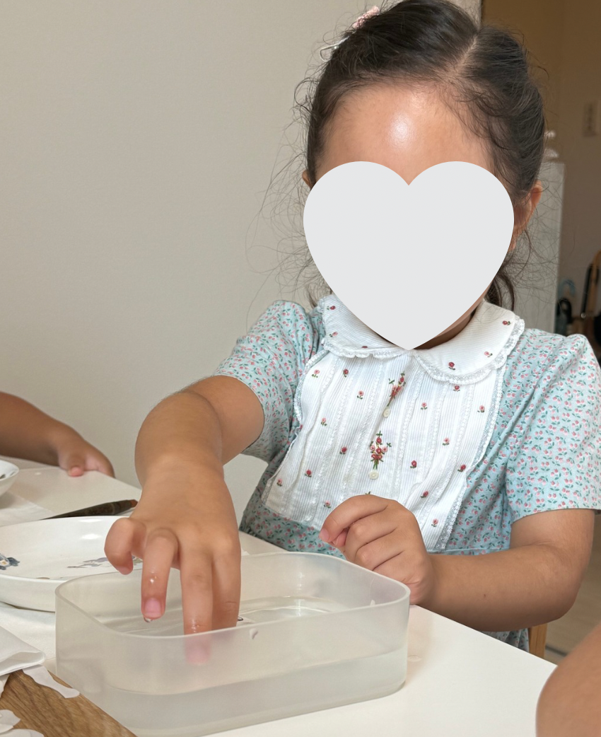 ポーセラーツの転写紙を水につけて自分で数を数える子ども